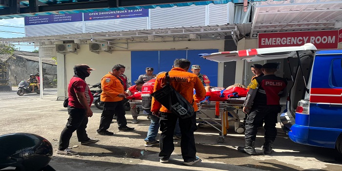 Petugas mengevakuasi wisatawan yang terpeleset saat menuruni tangga di tebing menuju objek wisata Pantai Kelingking.