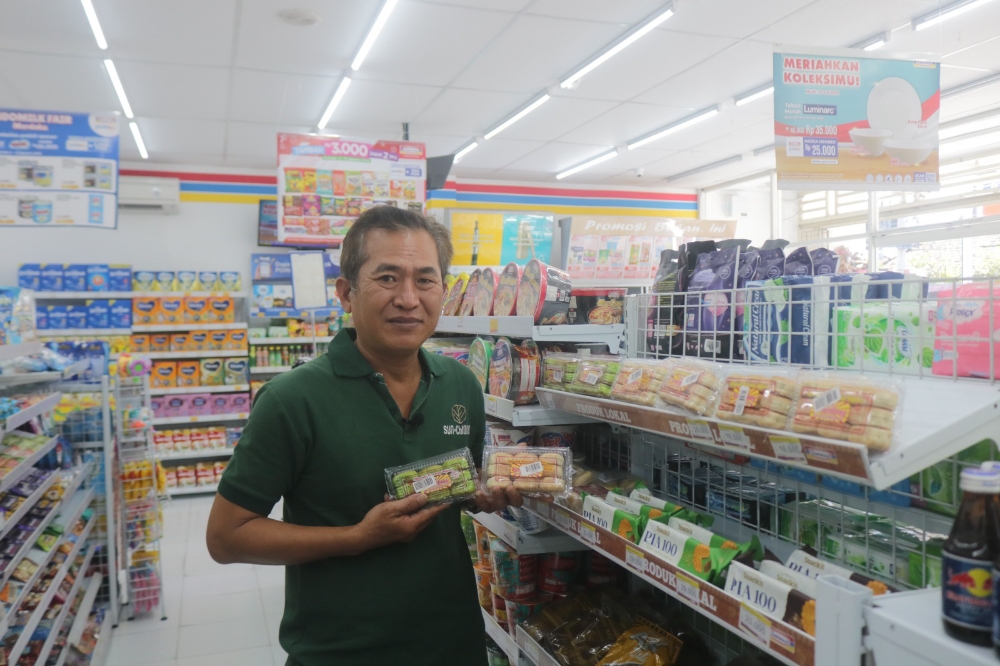 TERUS BERINOVASI: Irwan Sunarto memperlihatkan Pia Cemerlang yang hadir di Indomaret. (Radar Bali Photo)