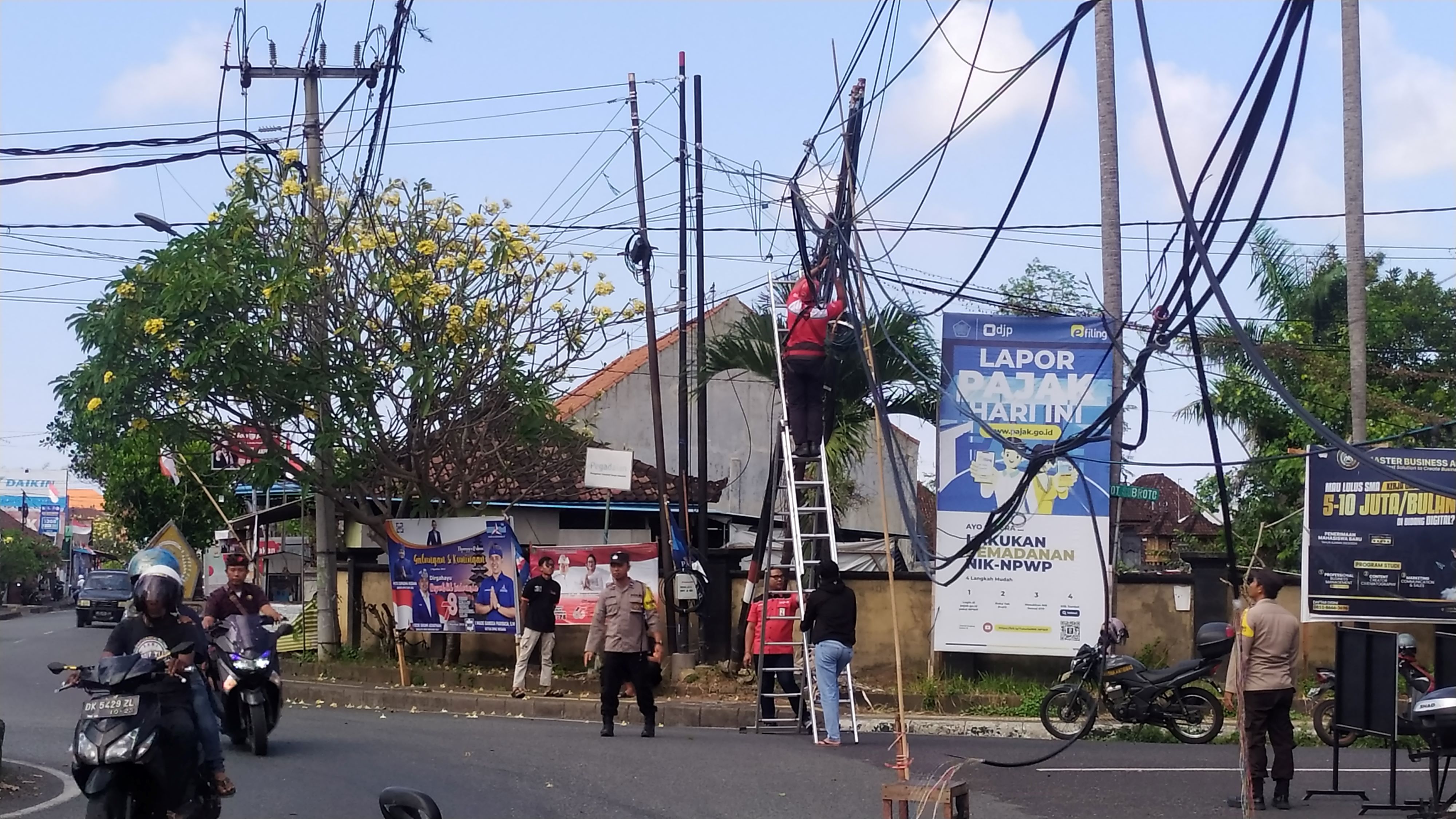 LUAR BIASA KACAUNYA KABEL INI: Perbaikan kabel yang sempat terangkut truk di simpang empat tugu jam Kecamatan Negara. (m.basir/radar bali)