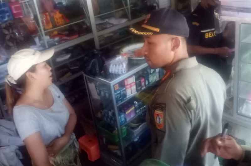 RUTIN MERAZIA : Satpol PP Karangasem dan Bea Cukai saat melakukan razia rokok ilegal di sejumlah warung yang ada di Kecamatan Abang dan Kubu. (istimewa)