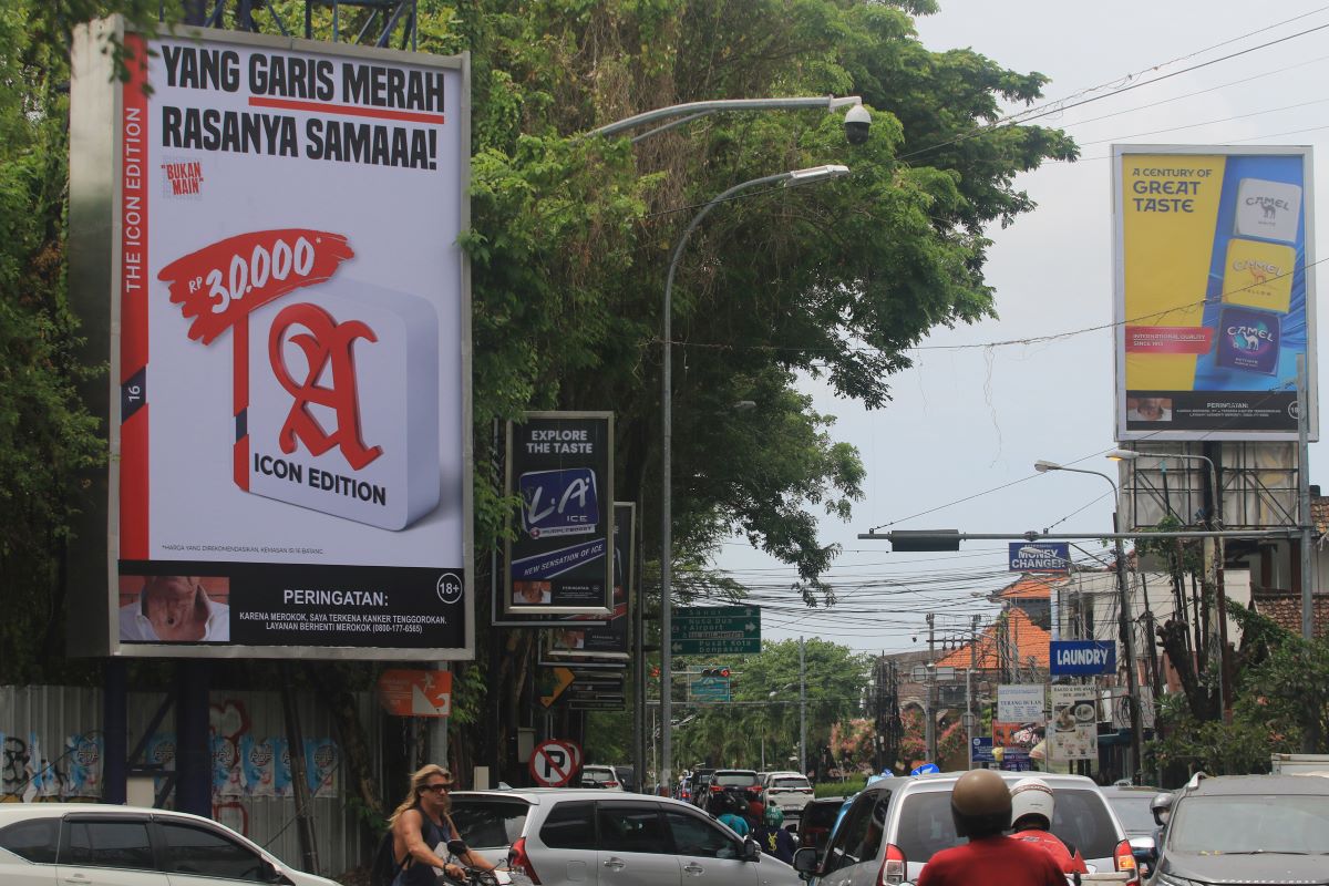 TERANG-TERANGAN: Iklan sebuah produk rokok ternama di Indonesia di pancang di area terbuka kawasan jalan Patih Jelantik Legian, Kuta, Badung.