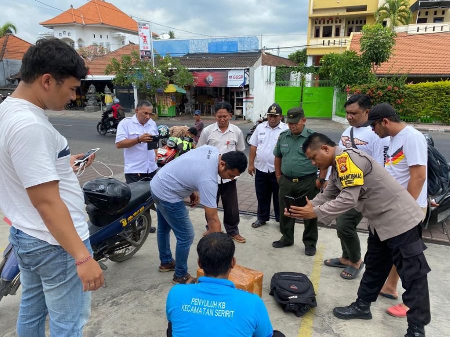 PARAH: Aparat BNNP Provinsi Bali dan polisi sedang membuka barang bukti ganja yang dibawa tersangka yang ternyata seoprang PNS berugas sebagai penyuluh KB di Seririt Buleleng.