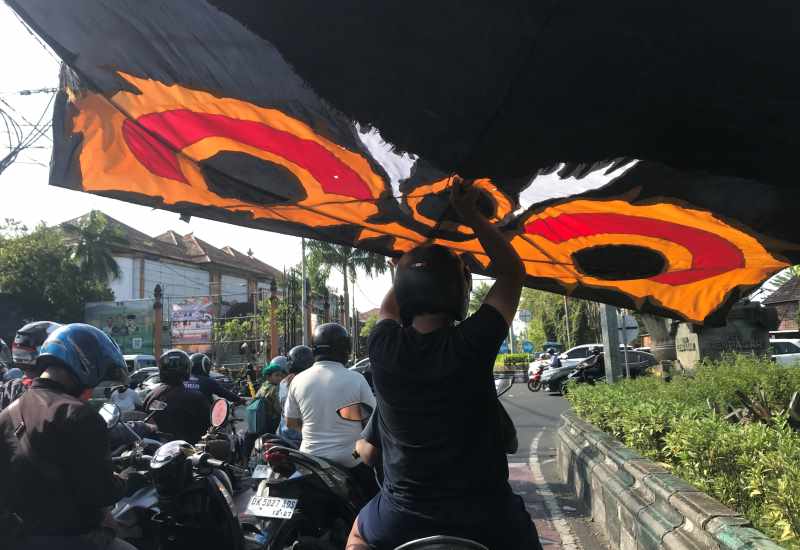 PERLU MENJAGA KESEIMBANGAN EKSTRA : Membawa layangan besar dengan naik motor saat melintas di Jalan Sudirman, Denpasar. (miftahuddin/radar bali)