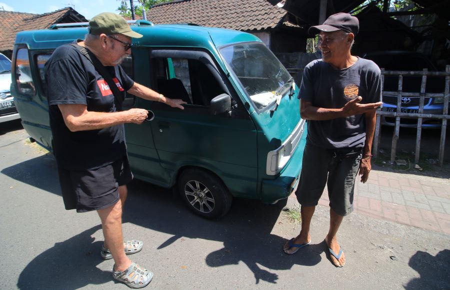 BERTAHAN: Made Ada (kanan), sopir angkot Trayek Kreneng-Sanur, saat berbincang dg tamu wisatawan asing, salah satu langganannya, di depan Pasar Sindu Sanur, tempat ngetem sejumlah angkot lama.