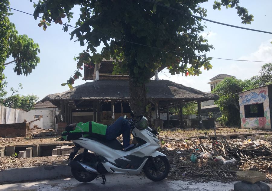 PULAS: Seorang driver ojol tampak pulas diatas motor ditengah terinya matahari siang (16/9/2023).