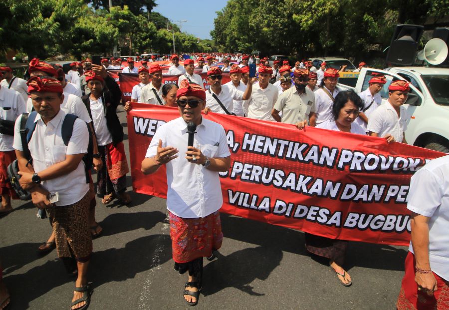 HENTIKAN PROVOKASI!: I Nengah Yasa Adi Susanto (pegang mik), Koordinator Tim hukum dan warga  Desa Adat Bugbug saat berjalan dari parkir timur renon menuju di kantor DPD Bali.