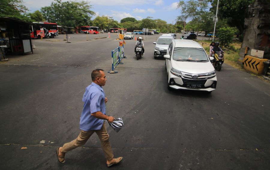 CALON PENUMPANG: Seorang warga kota bergegas lari menuju bus Trans Metro Dewata, di kawasan jalan Raya Kuta, 22 September 2023.