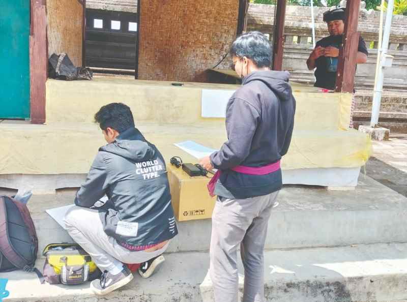 BUTUH PERJUANGAN: Petugas provider rekanan Diskominfo Badung memasang perangkat internet di Pura Pucak Mangu. [istimewa]