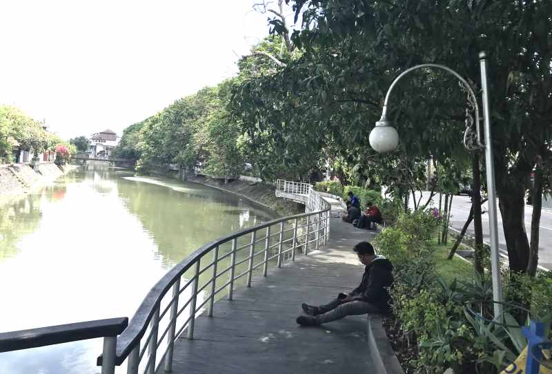 NGADEM DULU : Sejumlah warga tampak ngadem dulu di area bantaran Tukad Badung di kawasan Banjar Buagan, Jalan Imam Bonjol, Denpasar. (miftahuddin m.halim)
