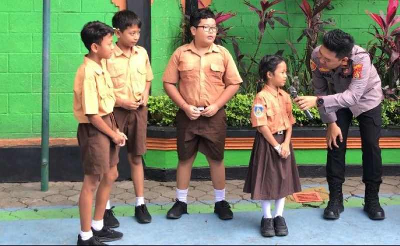 SANTAI NGOBROL DENGAN BOCAH : Kapolsek Denpasar Utara, Iptu I Putu Calros Dolesgit lakukan sosialisasi cegah kasus bullying di SD. (istimewa)