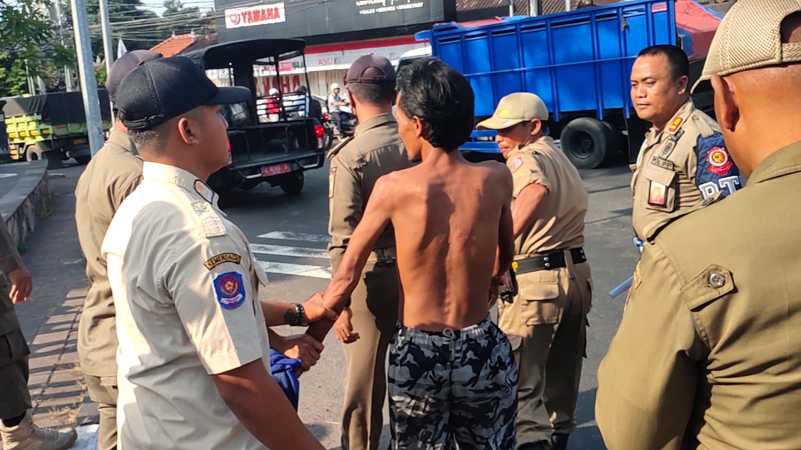 MERESAHKAN : Petugas Satpol PP Kabupaten Karangasem saat melakukan pengamanan terhadap ODGJ yang ngamuk dan meminta uang ke pedagang di Pasar Karangsokong, Karangasem. (istimewa)