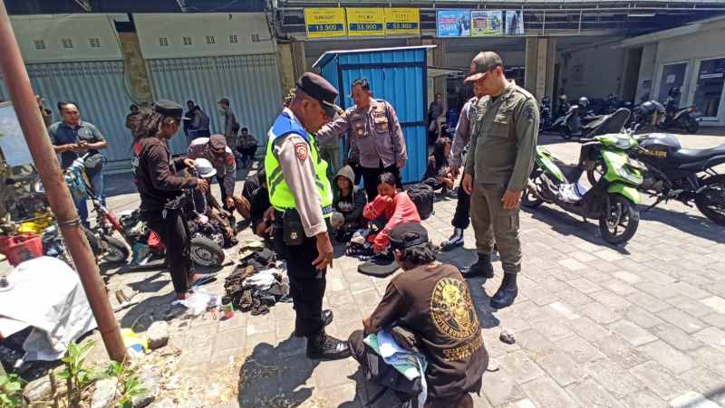 DIPERIKSA : Polisi dan satpol PP menginterogasi 10 orang yang tidur depan toko Jalan Denpasar - Gilimanuk .(m.basir)