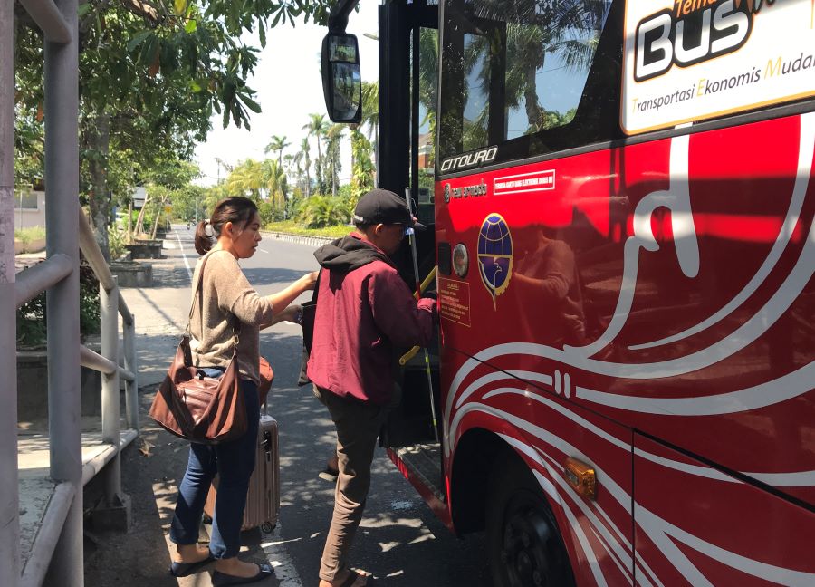 KEMANUSIAAN: Made Rasa, 50, seorang penyandang disabilitas netra (penglihatan) dibantu seorang penumpang naik bus Trans Metro Dewata, dari halte Sudirman, Denpasar (8/10/2023)