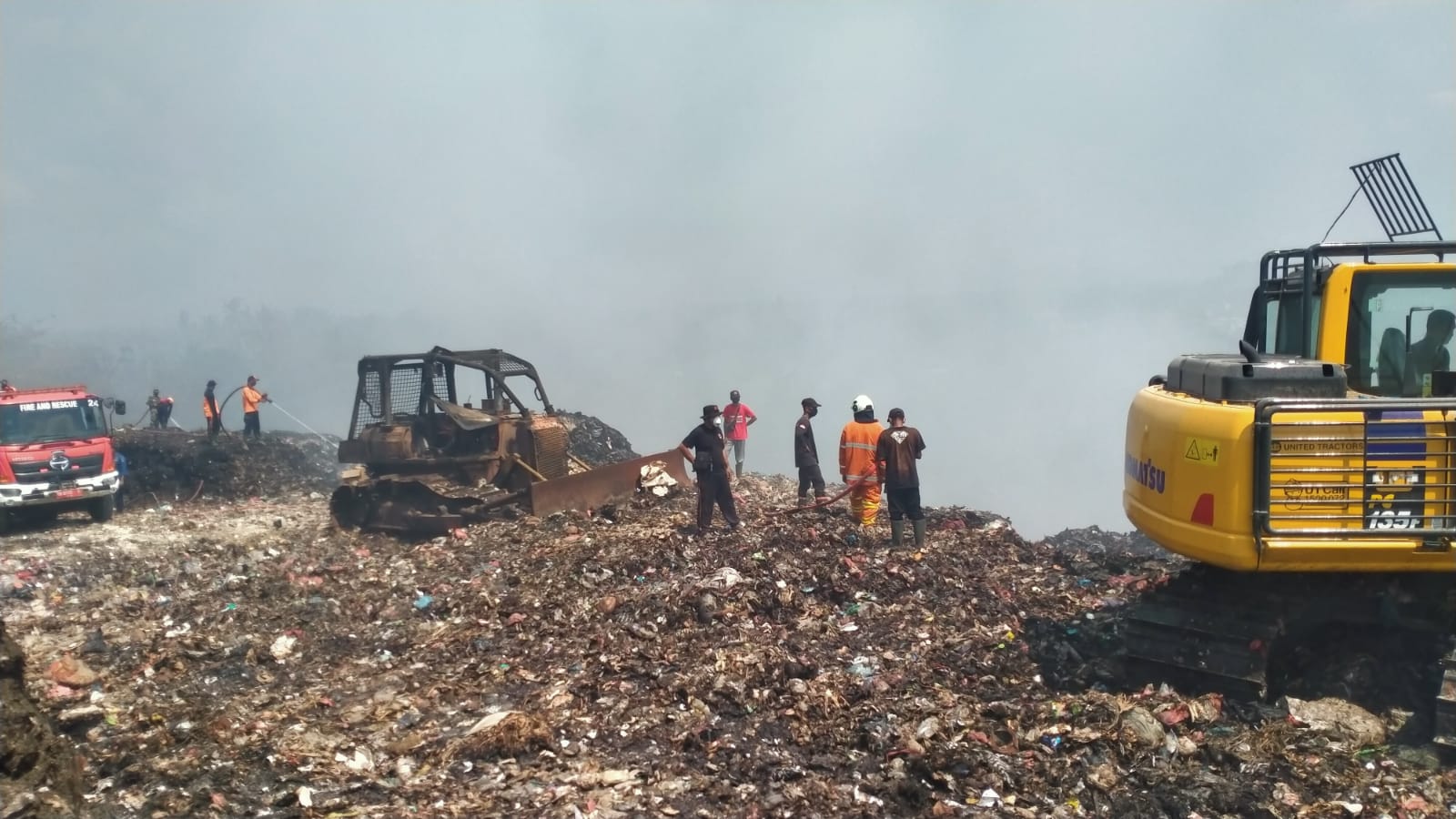 INOVASI: Petugas dan warga membuat cara baru memadamkan api di TPA Mandung Tabanan dengan membuat lupang yang di isi air di tumpukan sampah.