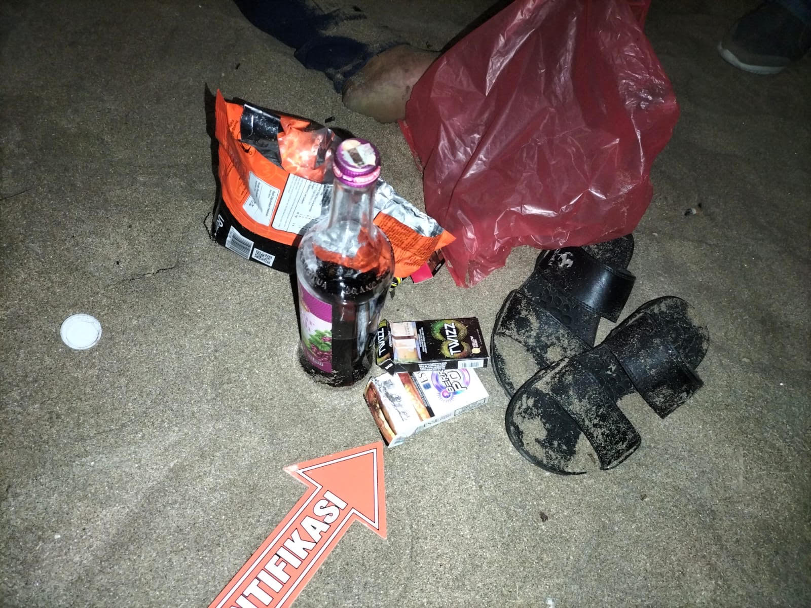 BERALKOHOL: Barang bukti minuman alkohol jenis anggur merah, rokok, makanan ringan dan sandal yang ditemukan dekat mayat Galih di pantai Legian.