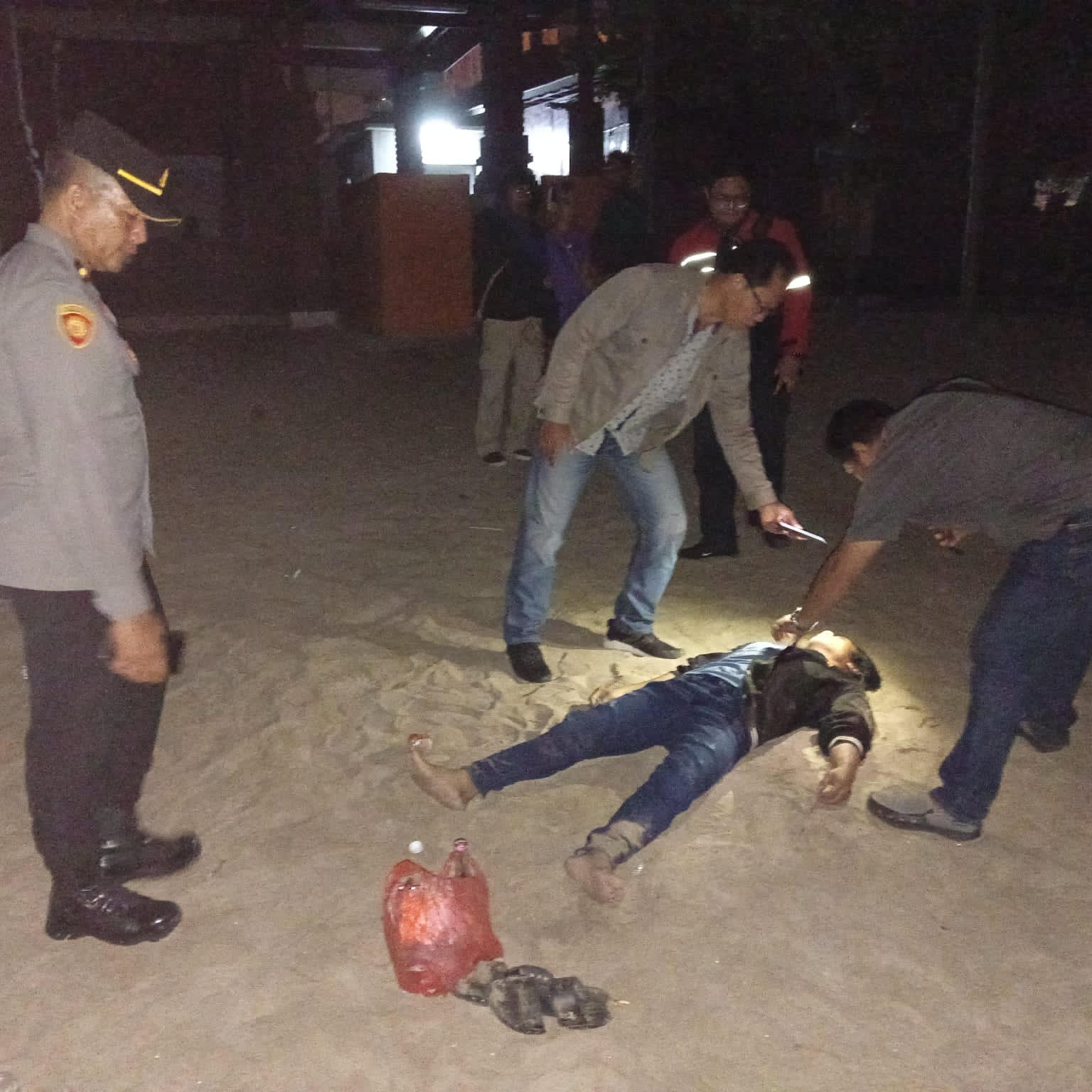 MENINGGAL DI PANTAI: Petugas sedang melakukan identifikasi terhadap seorang pria yang diketahui bernama Galih di Pantai Legian Kuta 23 Oktober 2023 dini hari.