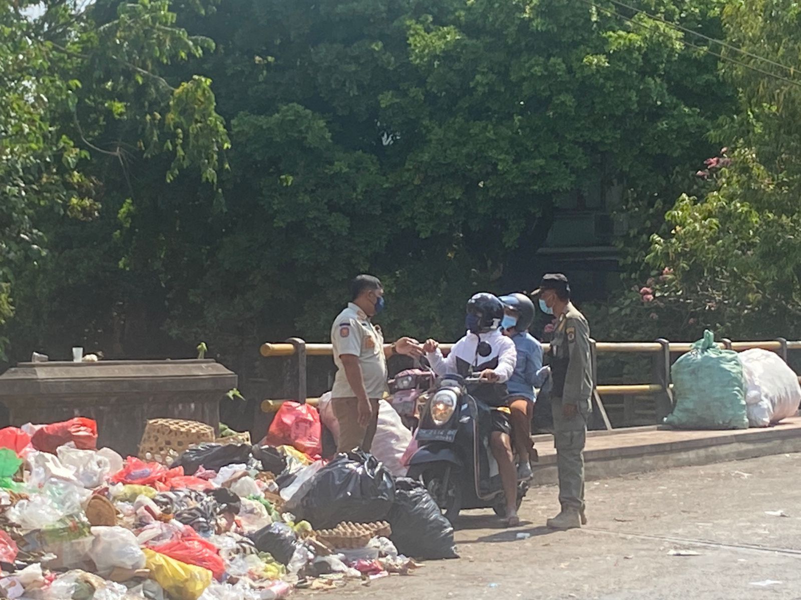 MELUBER: Satpol PP mengecek dan pergoki pembuang sampah di tumpukan sampah yang sudah meluber di Denpasar.