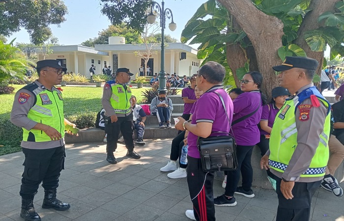 Polisi membagikan selebaran pemilu damai.