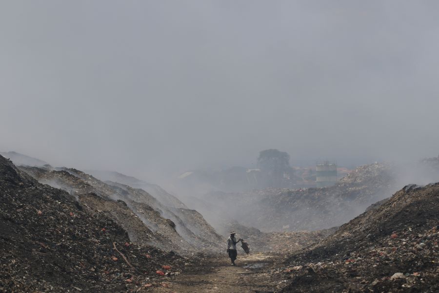 BELUM PADAM: Seorang pemulung mencari barang-barang bekas di area TPA (Tempat Pemrosesan Akhir) sampah di Suwung, Denpasar, kemarin (23/10). Kebakaran TPA Suwung terjadi pada 12 Oktober lalu.
