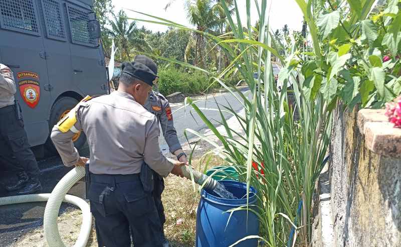 BERBAGI AIR BERSIH : Distribusi air bersih di Banjar Benel Desa Manistutu, Kecamatan Melaya. (foto: polres jembrana)