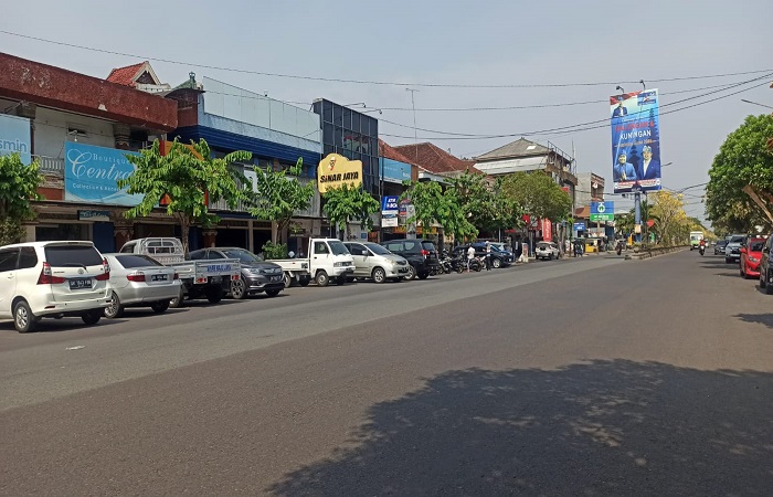 Parkir tepi jalan umum naik bagi kendaraan roda dua dan roda empat di Jembrana. Tampak area parkir di pinggir Jalan Ngurah Rai, Kota Negara.