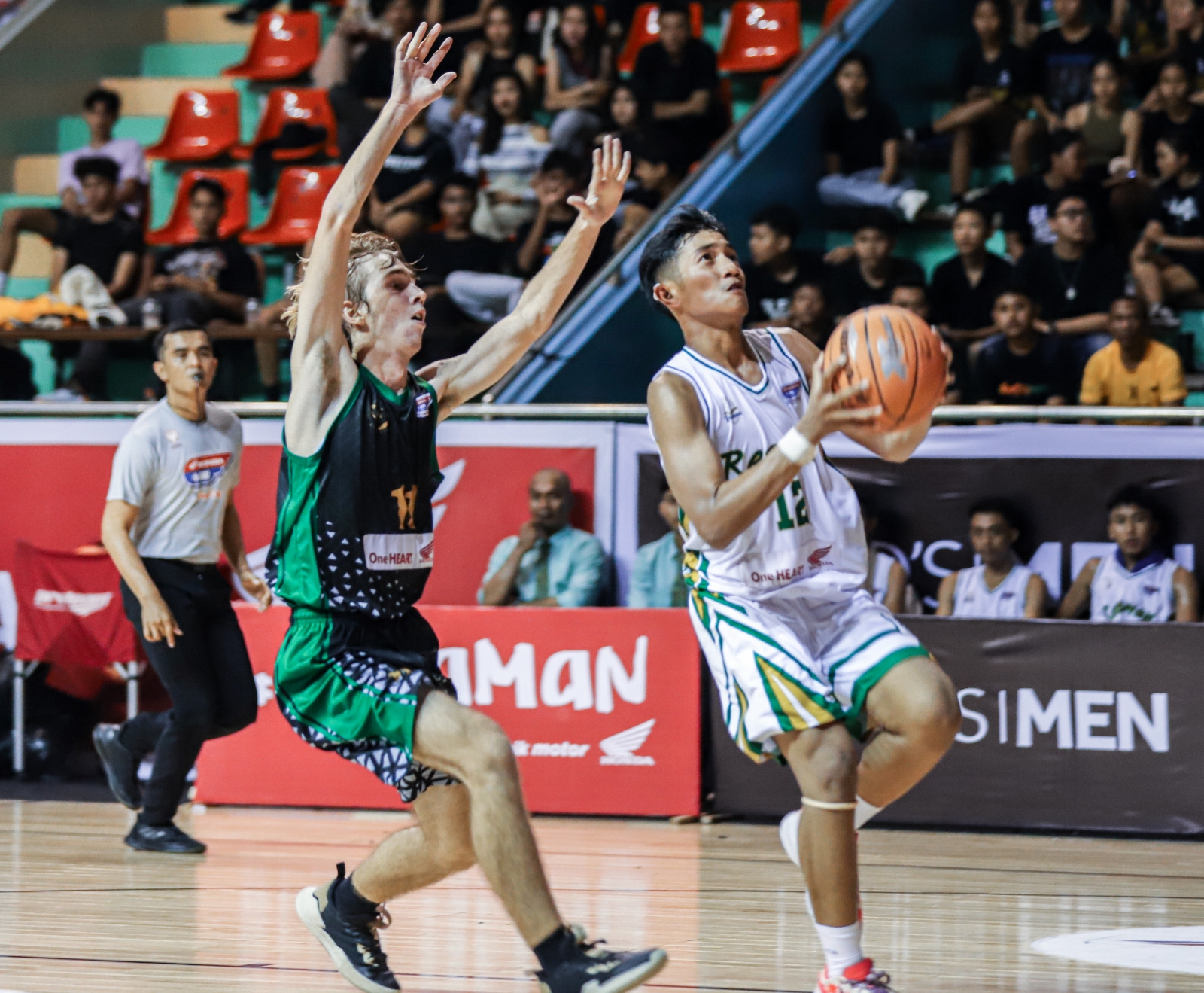 KE PUNCAK: Guard Resman Abhynaya Narayana (kanan) bersiap melakukan layup dalam kawalan forward SMA Dyatmika Stefan Loghin (2/11). (DBL INDONESIA)