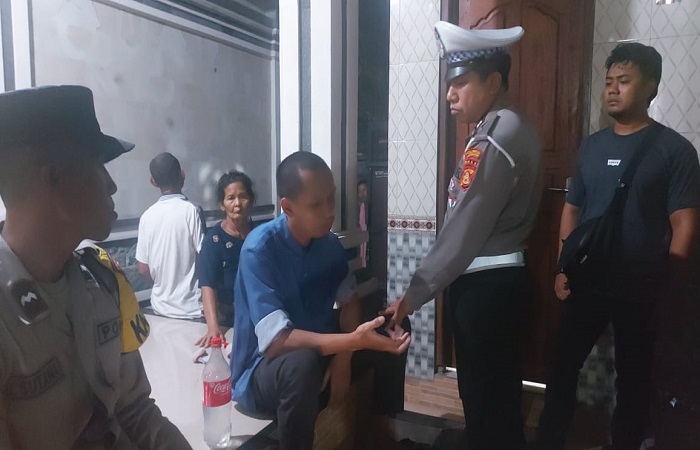 Pelaku (baju biru) saat diamankan aparat kepolisian usai membacok ayah kandungnya sendiri, pada Senin malam (6/11) lalu.
