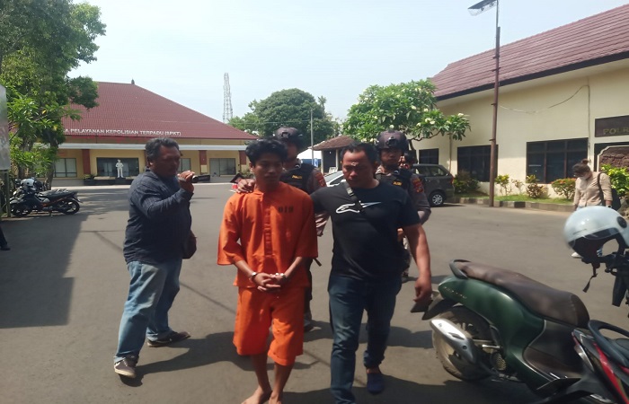 Tersangka Kholidin dikawal polisi ke sel tahanan.