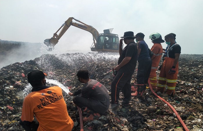 Petugas Damkar, DLH dan BPBD Tabanan yang melakukan penyiraman titik api di TPA Mandung, Tabanan.