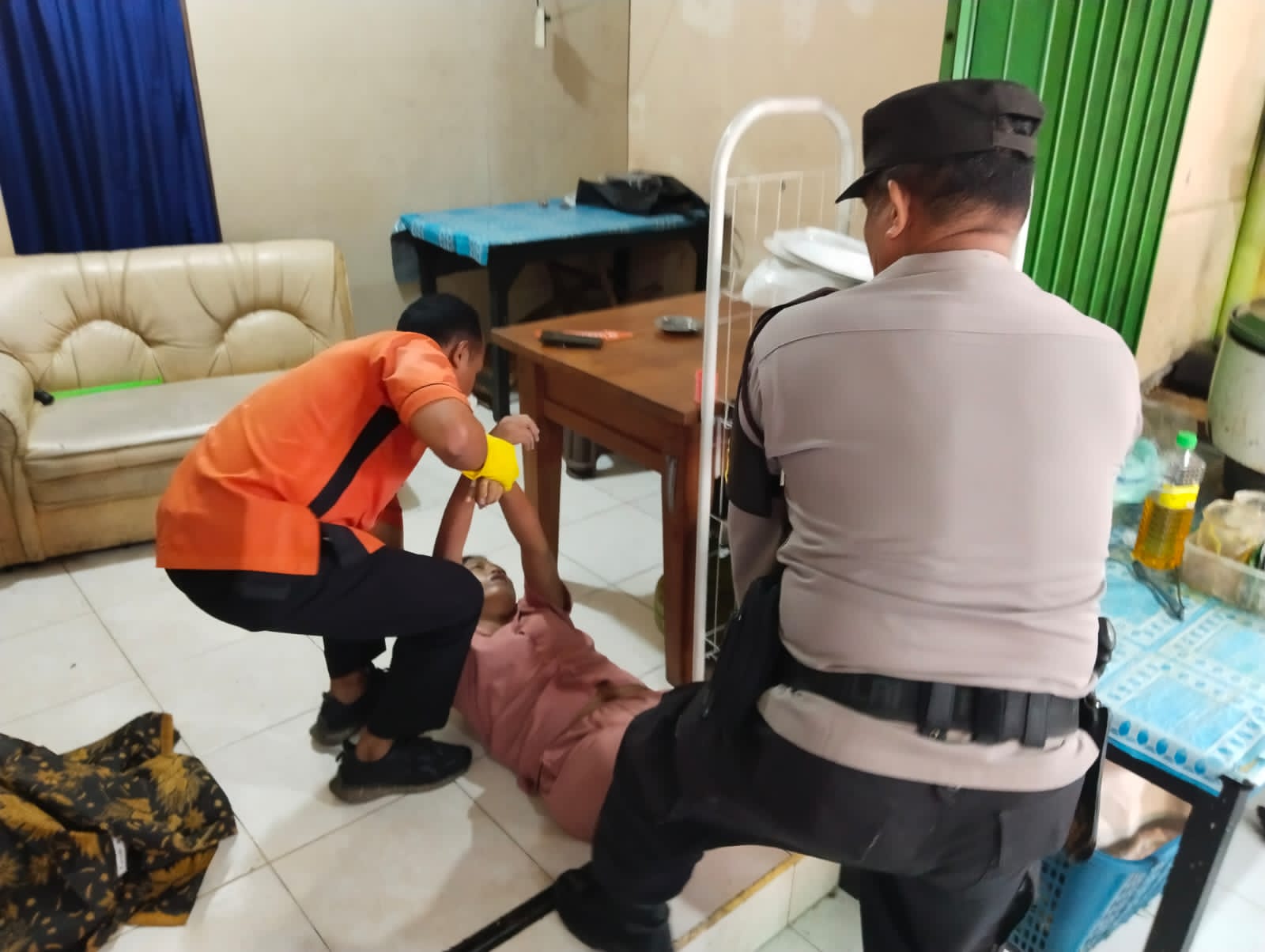 DI EVAKUASI: Seorang wanita pelayan warung Banyuwangi di kawasan jalan Keboiwa Denpasar ambruk dan meninggal. Petugas sedang mengevakuasi untuk membawa ke ambulans.