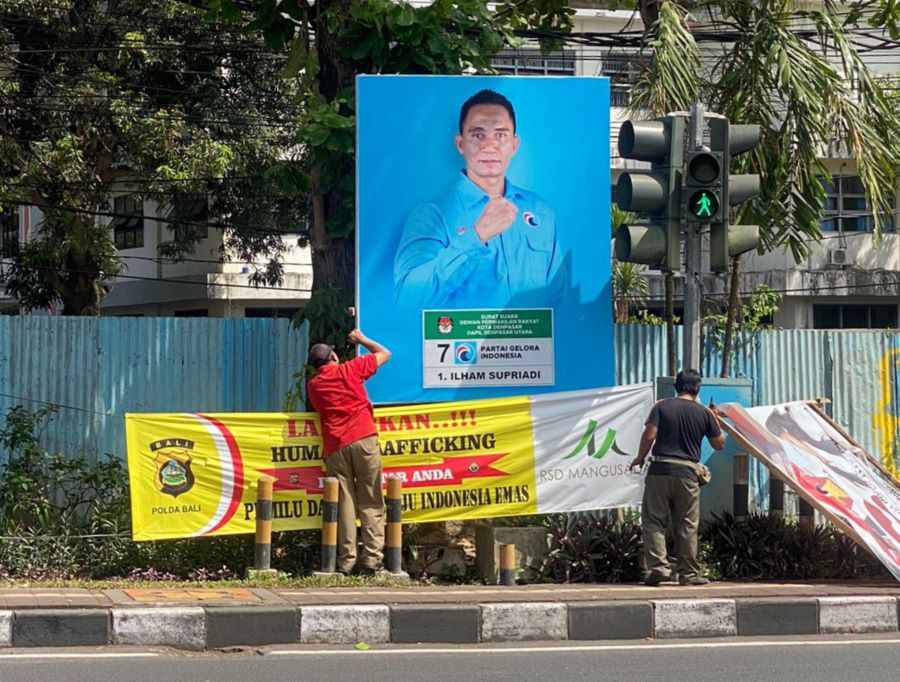 DIROBOHKAN: Aparat Satpol PP Kota Denpasar menurunkan sejumlah alata perraga kampanye milik caleg yang bandel tak dirurunkan sendiri.