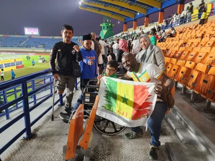 HARI BAHAGIA : Atlet disabilitas Boccia Indonesia, Muhammad Fadhil (kursi roda) berpose dengan pendukung Senegal di Stadion Si Jalak Harupat, Bandung, Jumat (17/11). (media PSSI)