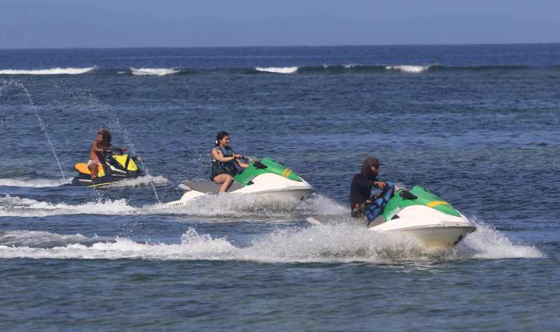 DITEMANI PEMANDU : Wisatawan tampak menikmati wahana wisata air, jet ski di kawasan pantai Tanjung Benoa, Nusa Dua. (miftahuddin.m.halim/radar bali)