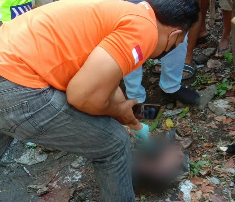 EVAKUASI: Anggota BPBD Kota Denpasar mengevakuasi jenazah orok yang terlindas kendaraan setelah Polisi Olah TKP, Selasa (21/11).