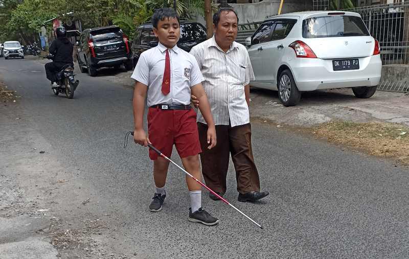 AJAK KENAL LINGKUNGAN : Seorang guru SLB/ A Dria Raba sebelah utara kantor Telkom  mengajari muridnya yang tuna netra. (adrian suwanto)