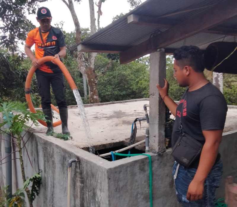 MEMBANTU WARGA : Petugas BPBD Karangasem saat menyalurkan air bersih ke cubang di Banjar Dinas Belong, Desa Ban, Kecamatan Kubu. (foto:BPBD Karangasem)