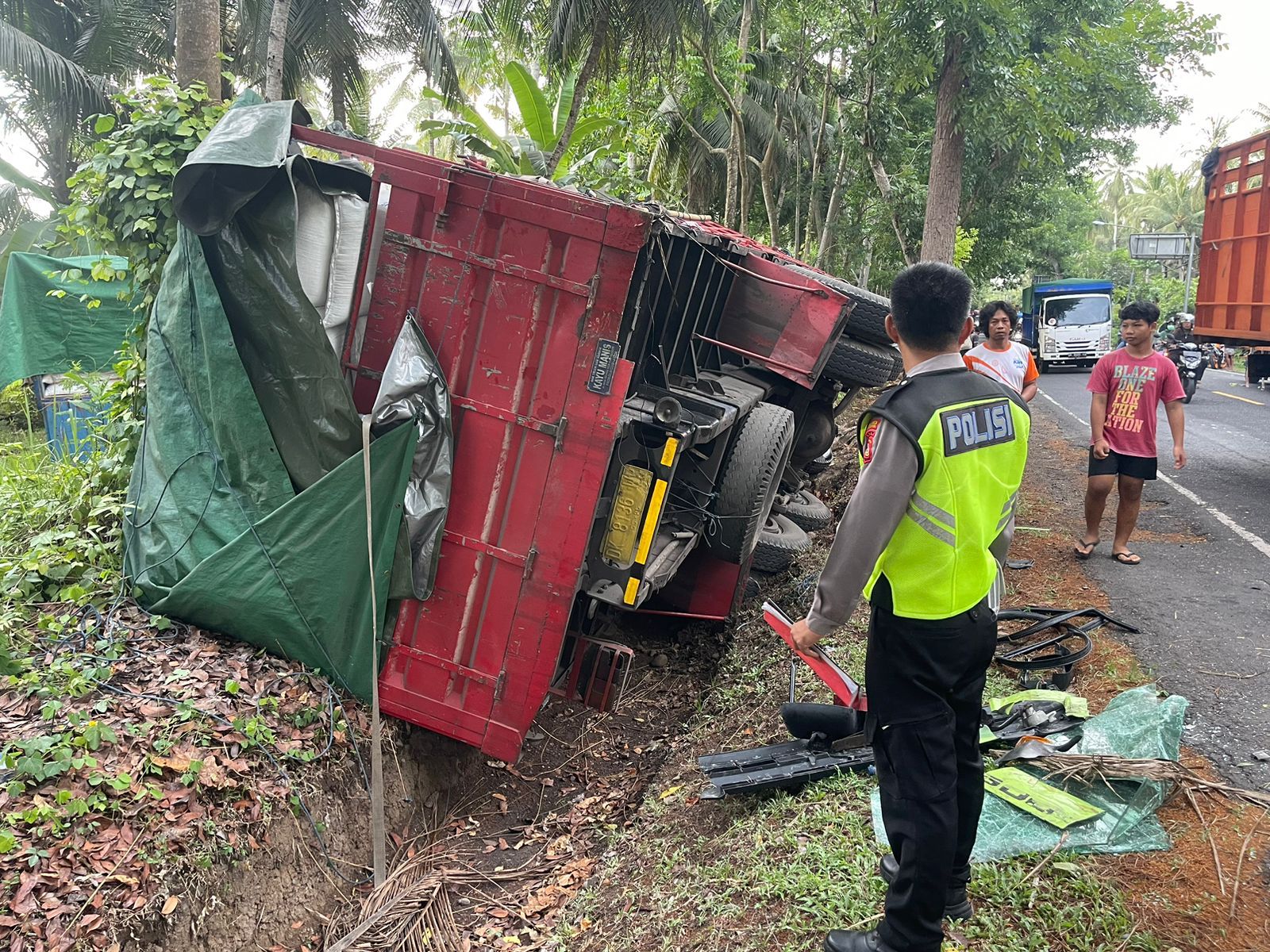 NAHAS: Truk jenis tronton yang terguling di jalan Denpasar - Gilimanuk.