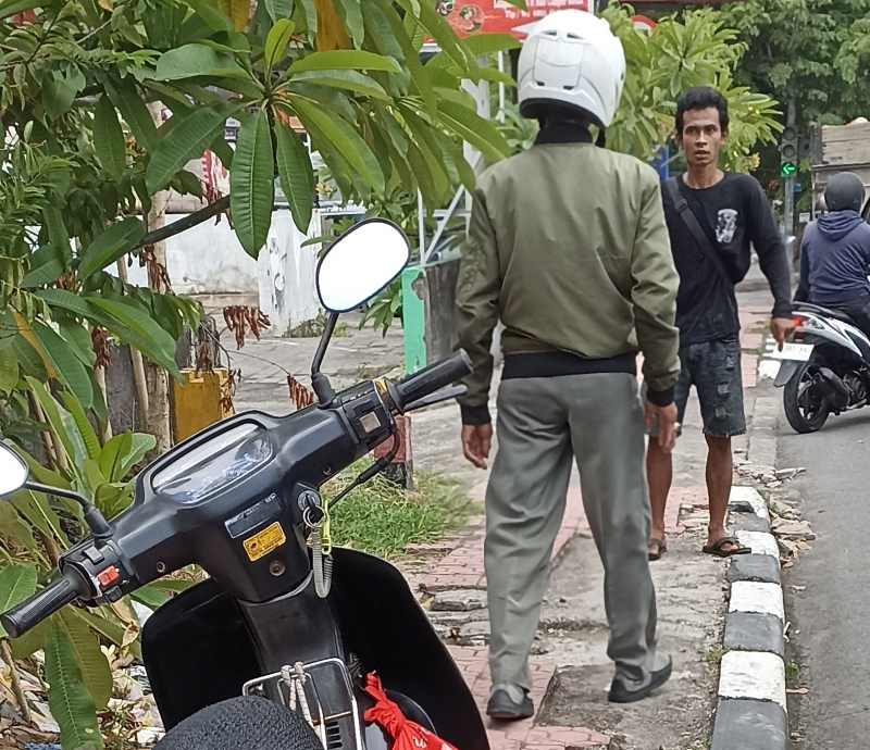 SAMA -SAMA EMOSIONAL : Pemotor naik trotoar disemprot pejalan kaki di Kawasan Jalan Gator Subroto, Denpasar. (foto: adrian suwanto/radar bali)