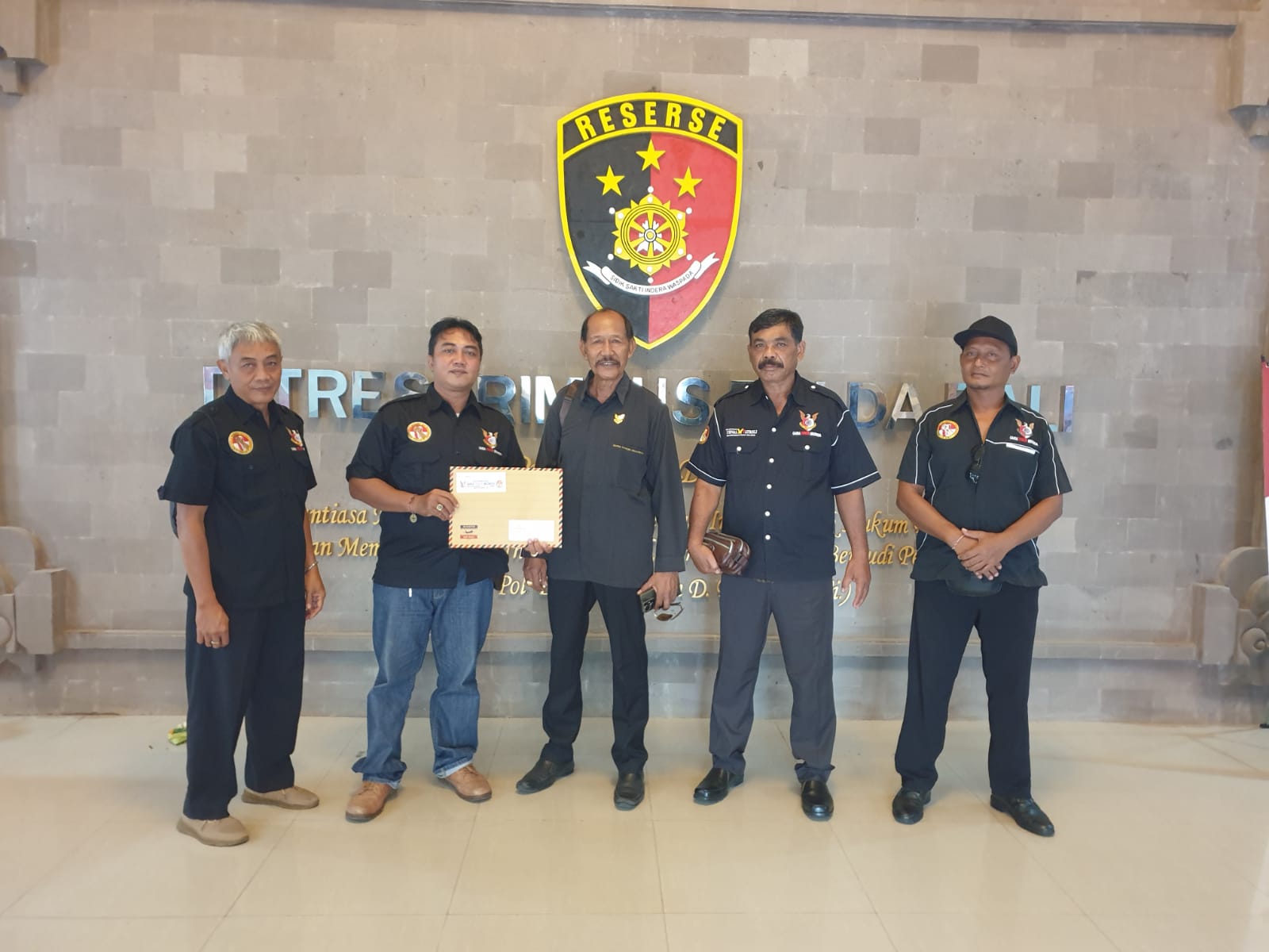 SEBENDEL BUKTI: Ketua DPD Garda Tipikor Pande Mangku Rata (tengah) dkk saat di Polda Bali melaporkan mantan Bupati Gianyar Agujs Mahayastra (4/12/2023).