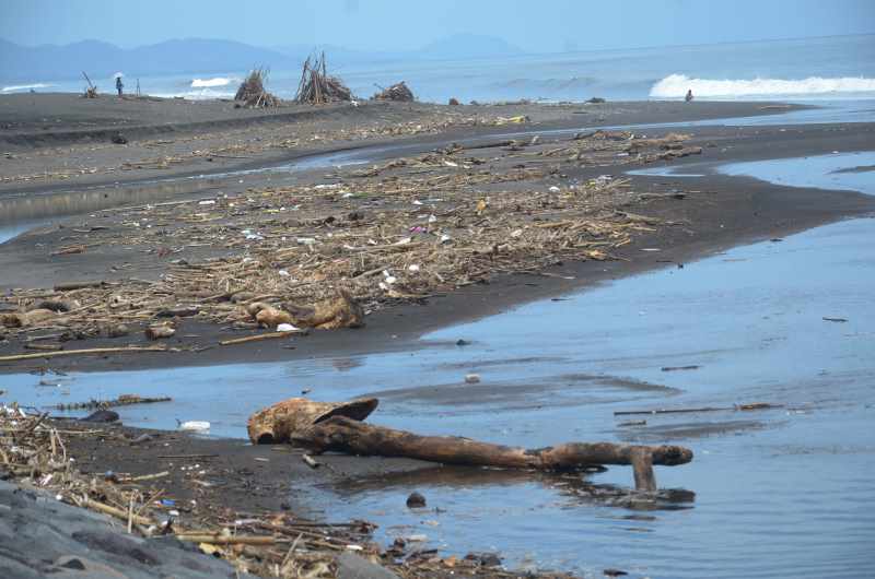 MULAI BERMUNCULAN : Sampah -sampah bermunculan dari laut teronggok di Pantai Kuta. Setiap akhir dan awal tahun ini menjadi rutinitas. (adrian suwanto/radar bali)
