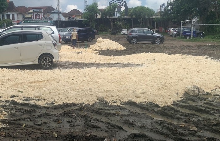 Proses pengurukan menggunakan batu kapur di lapangan Ubud Gianyar.