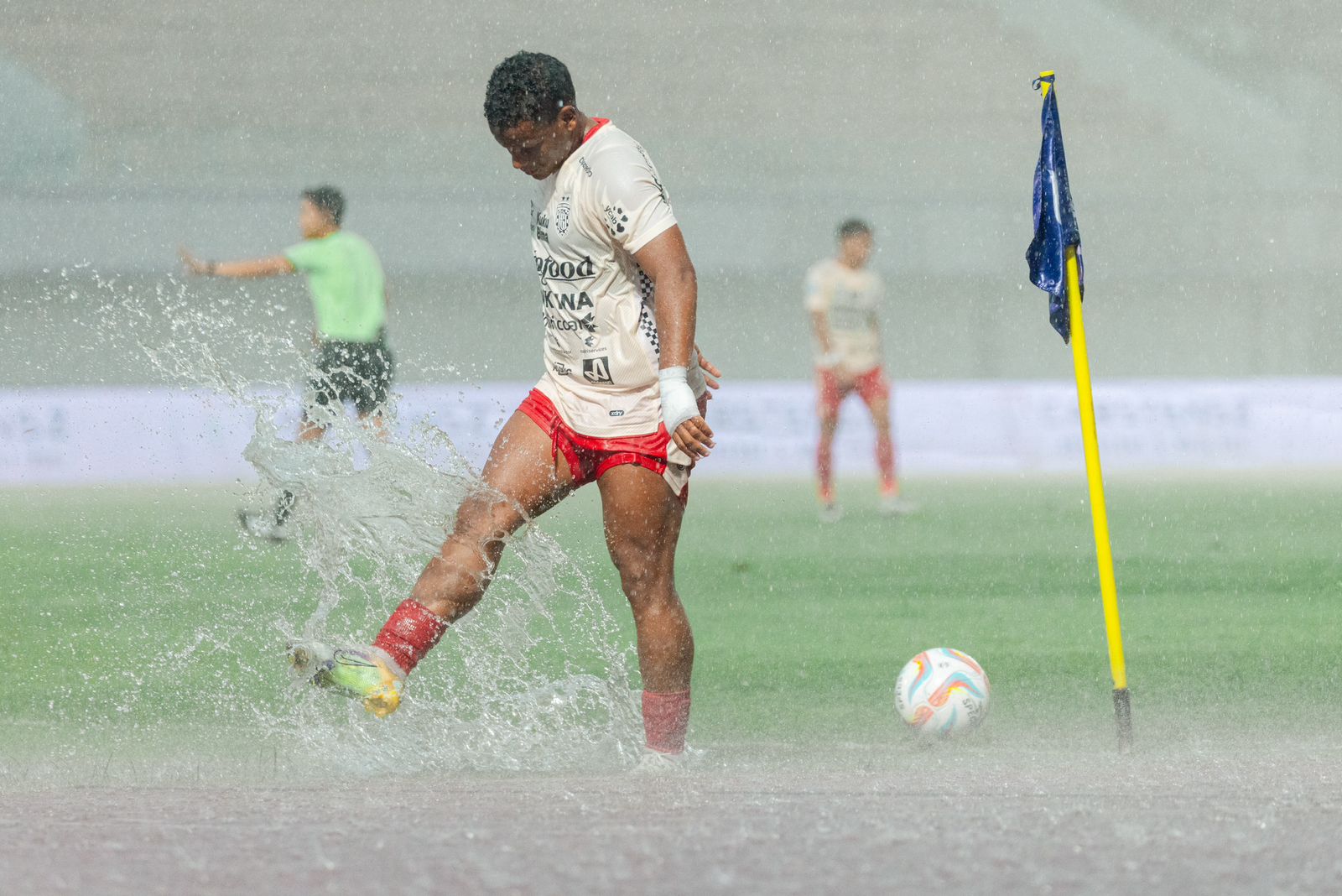HUJAN LEBAT: Striker asing Bali United Eber Bessa menepak genangan air di lapangan Indomilk Arena Tangerang. Ia mencetak 1 gol dalam laga tandang melawan Dewa United (8/12/2023).