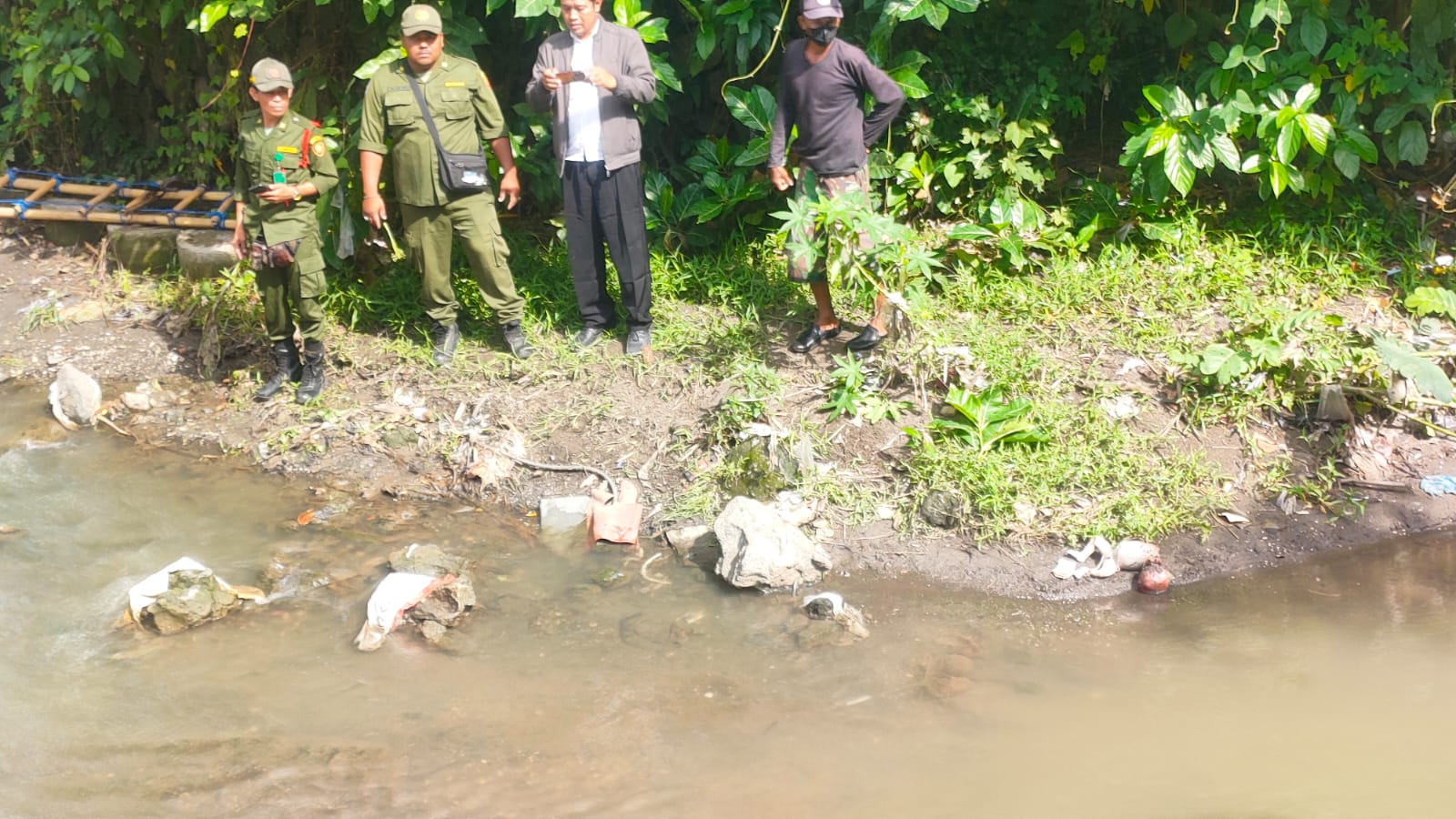 MISTERIUS: Polisi, Hansip, dan aparat BPBD Denpasar bersiap evakuasi bayi yang ditemukan meninggal di Tukad Mati Denpasar (10/12/2023)