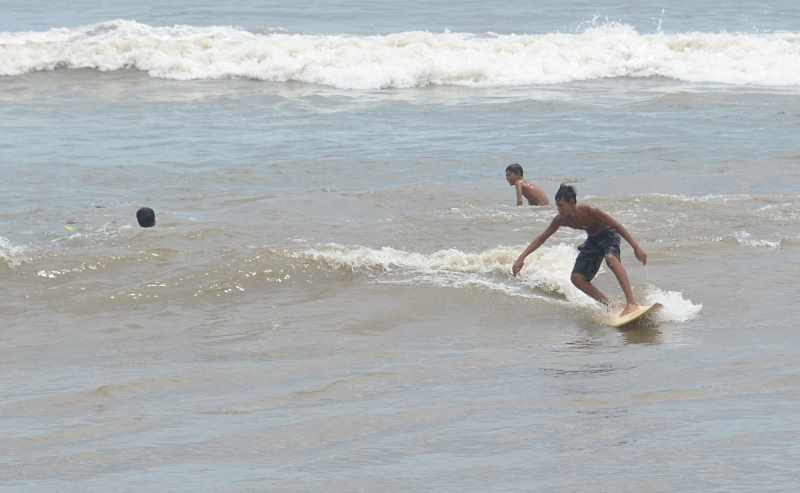 KOTOR KECOKLATAN : Sejumlah remaja bermain selancar di Laut Pantai Biaung, Denpasar. (adrian/radar bali)