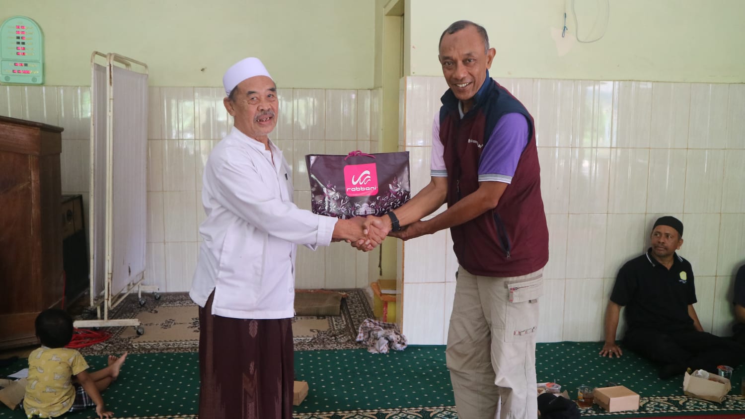 SIMBOLIK: Kepala Sekolah SD Muhammadiyah 4 Denpasar Agus Ekhwan (kanan) saat menyerahkan bantuan secvara simbolik kepada Pimpinan Ponpes Al-Iman Pegayaman KH I Nengah Sururuddin di Masjid setempat.