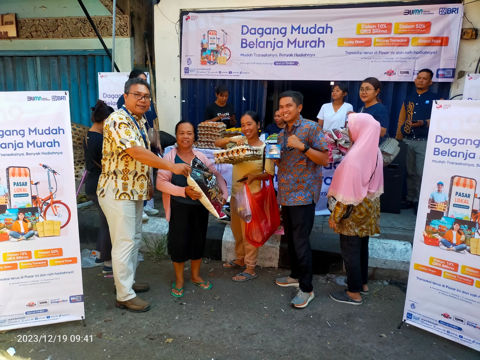 BELANJA DAN MENANG: Pemimpin Cabang BRI Singaraja, Panji Kurniawan (kanan) menyerahkan hadiah kepada masyarakat yang berbelanja dalam ajang pasar murah yang digelar BRI Singaraja