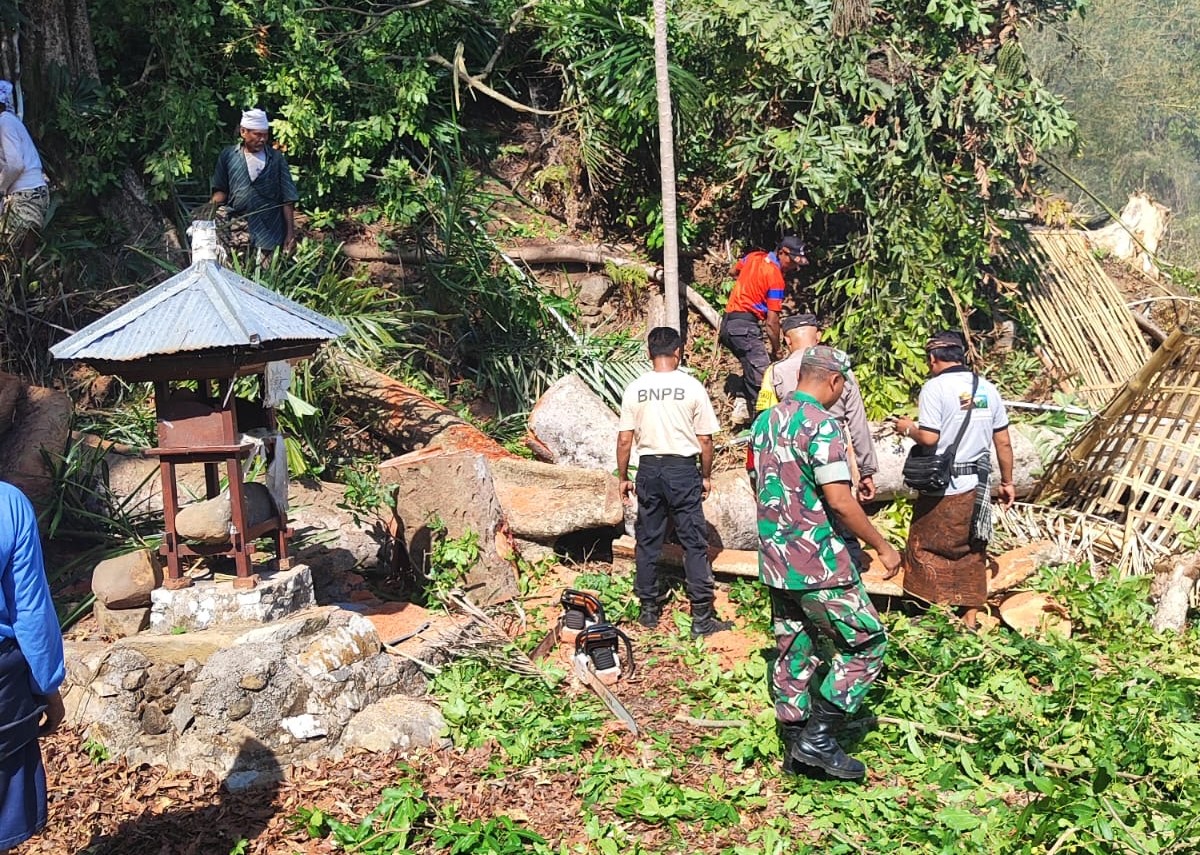 Warga dan aparat membantu pemotongan pohon tumbang sehingga tidak mengganggu lalulintas