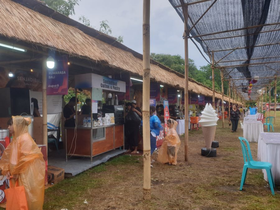 PAKAI MANTEL: Stan makanan di arena Denfest mulai sepi saat hari penutupan diguyur hujan lebat, 25 Desember 2023.