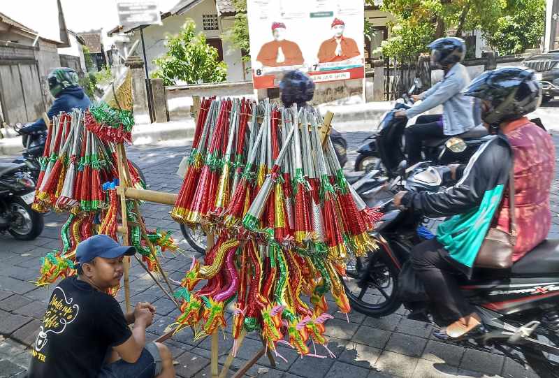 PRODUK MUSIMAN : Beraneka jenis dan ukuran terompet tahun baru banyak dijajakan di jalan raya Kota Denpasar. (adrian suwanto/radar bali)