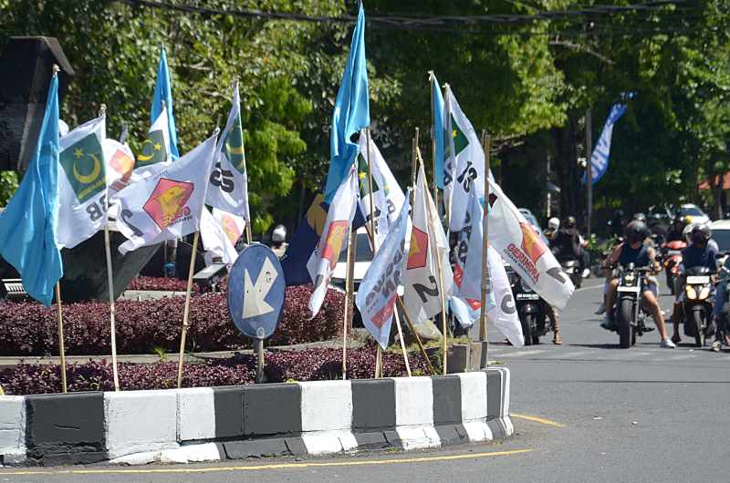 RAMAI BENDERA JELANG PEMILU : Sejumlah bendera parpol tampak bermunculan di sejumlah sudut jalan raya Kota Denpasar. (adrian suwanto/radar bali)